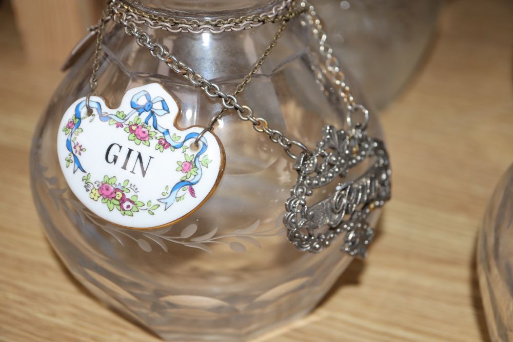 A pair of cut glass decanters, three other decanters, a claret jug and other glassware together with various labels, one silver whisky